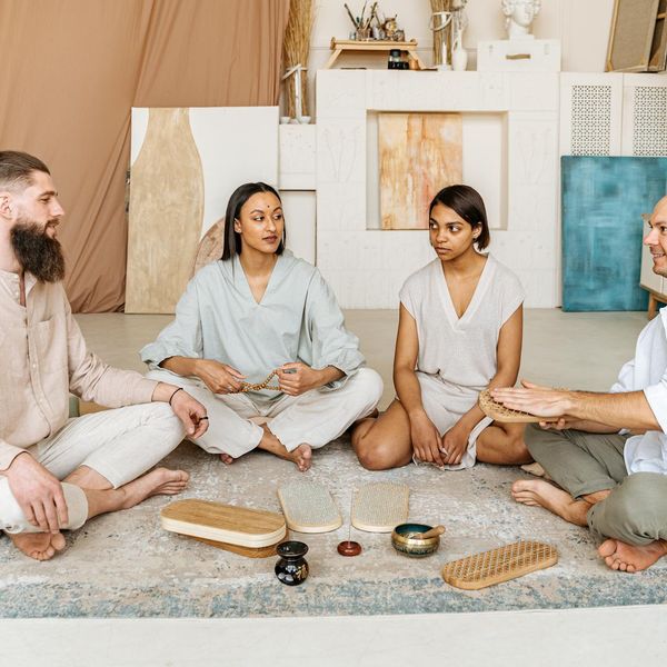 A group of diverse athletes meditating after a yoga session.